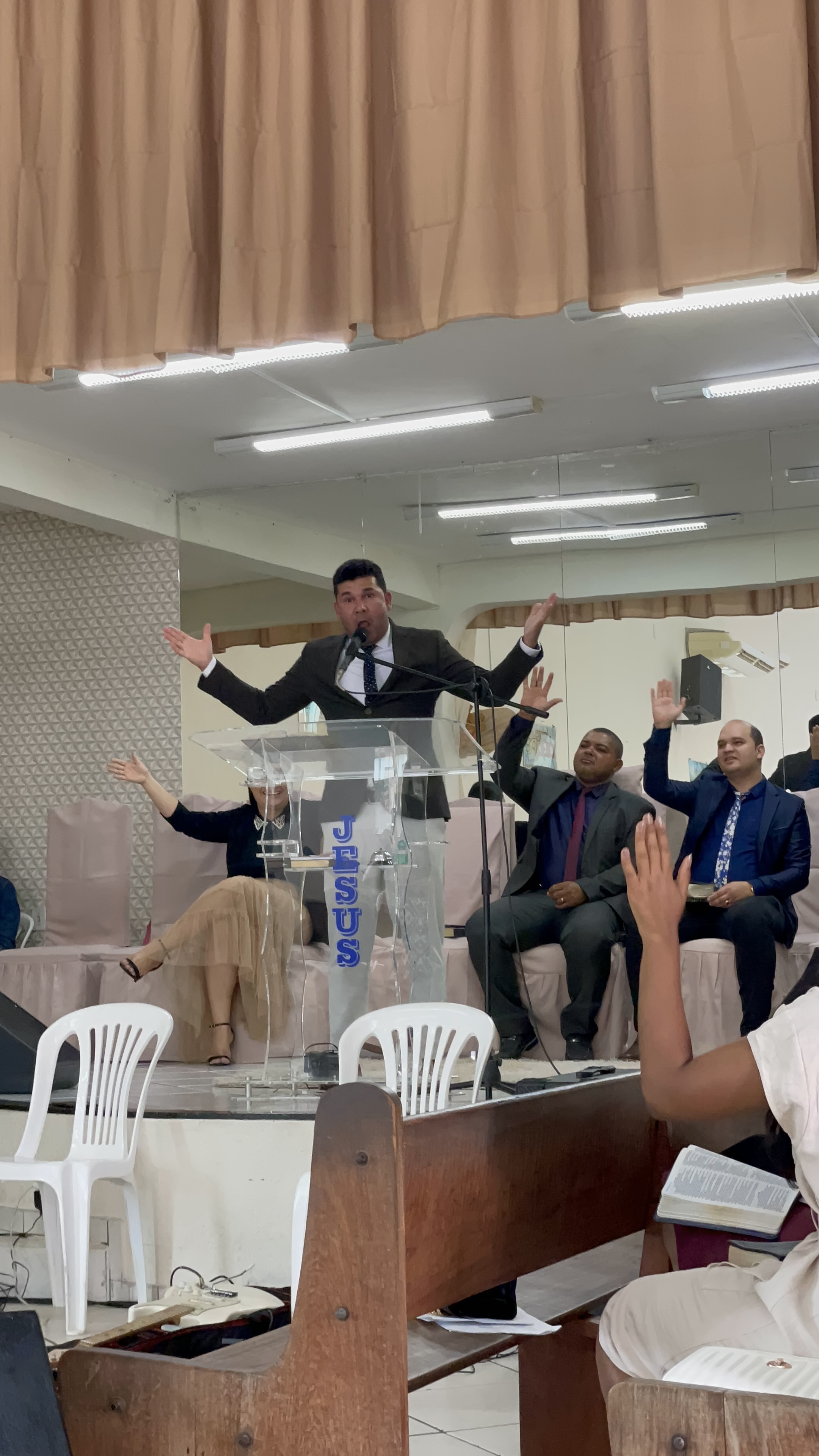 Gladston Freire ministrando no altar com mãos levantadas em adoração